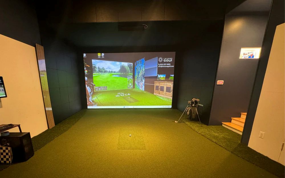 Custom residential golf simulator room with full turf floor